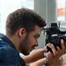 Fotógrafo ajustando câmera em locação